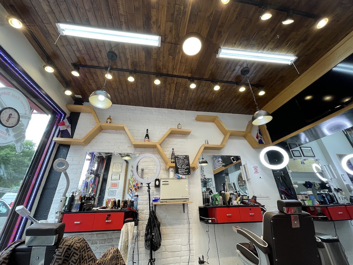 Lower East Side Barbers interior architecture: wood plank ceiling, hexagon wooden wall shelves on white brick, multiple ring lights