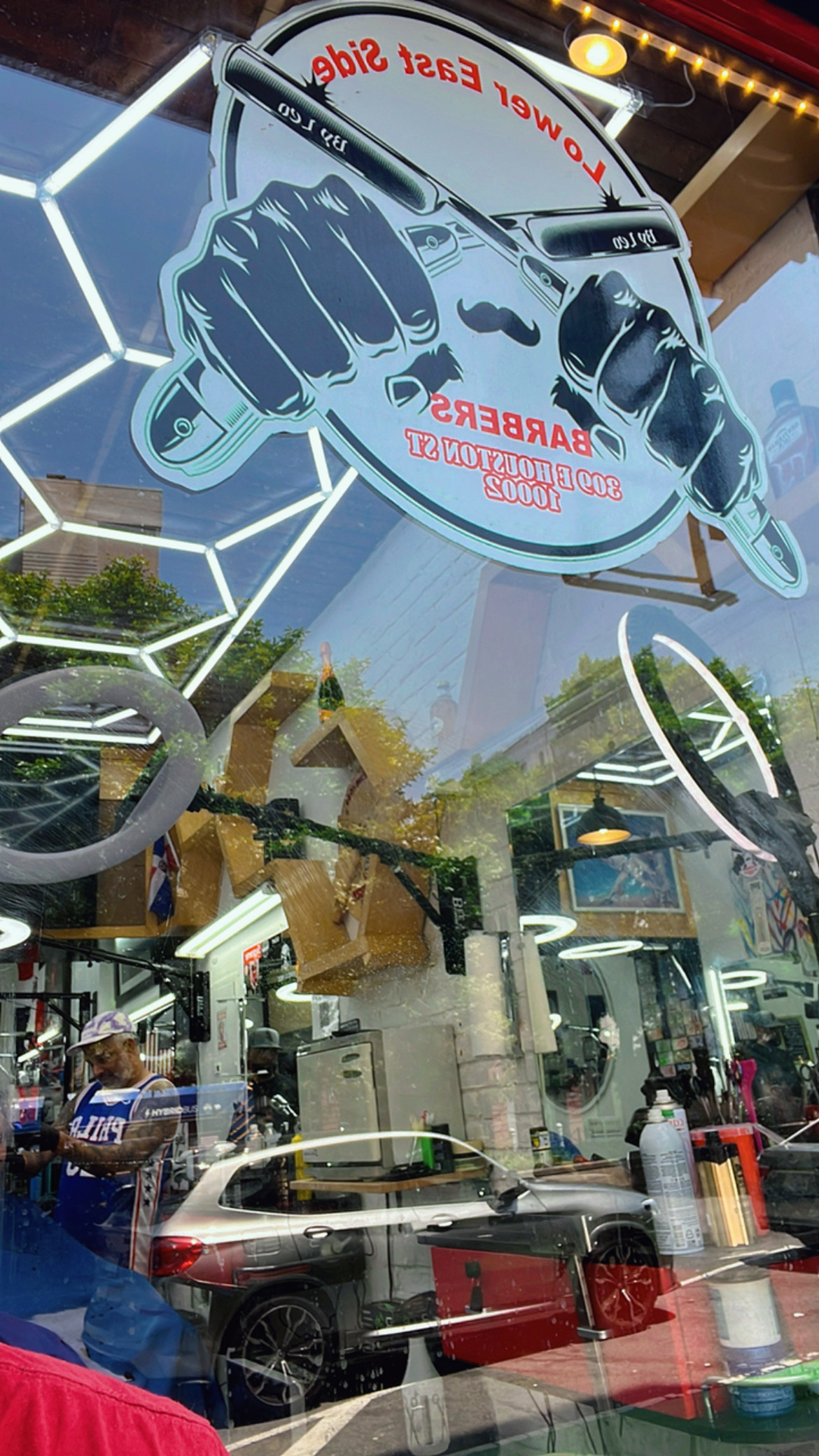 LES Barbers fist and mustache logo decal on shop front window, interior visible through glass